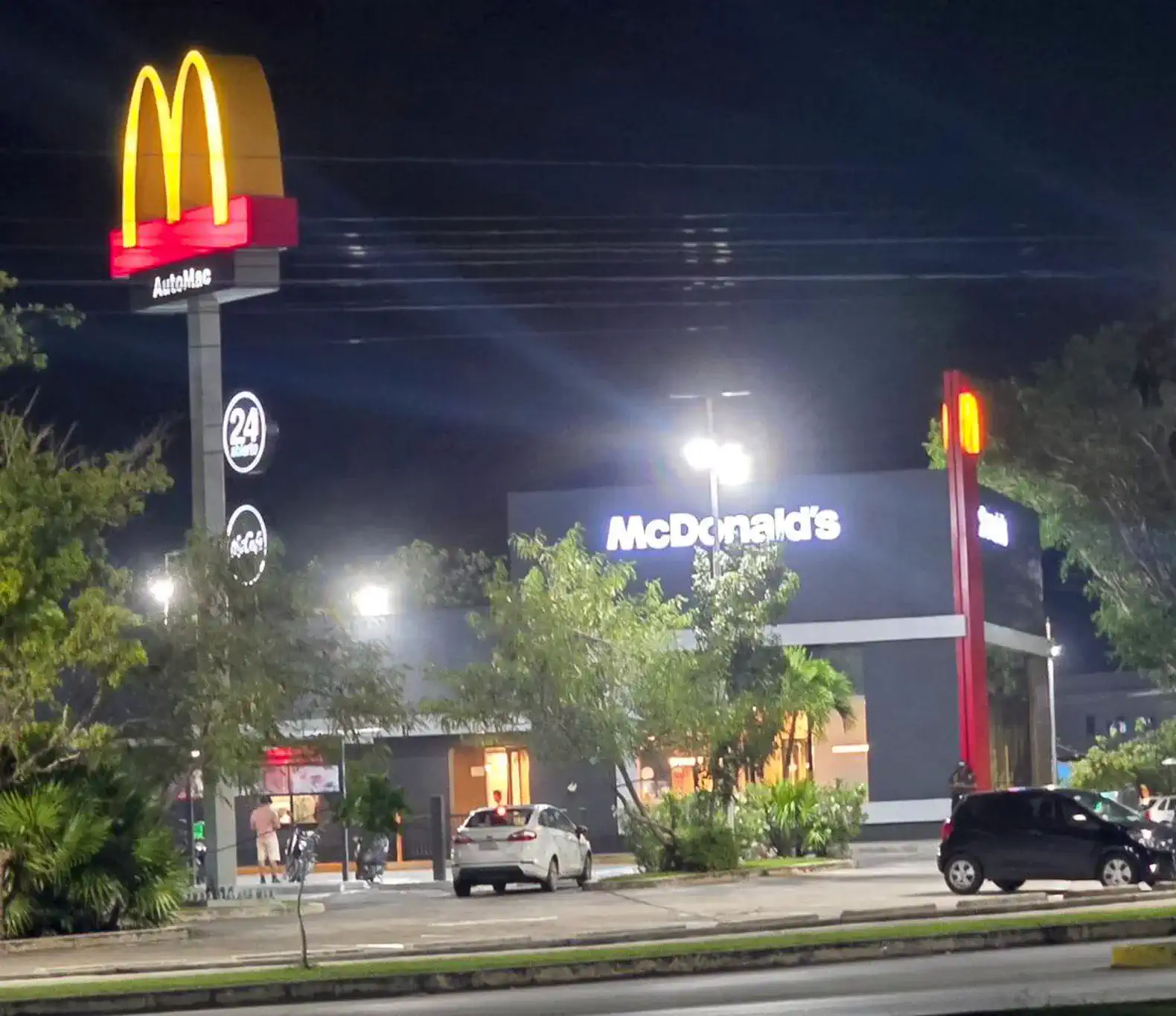 Modern McDonald's restaurant illuminated at night with a drive-thru