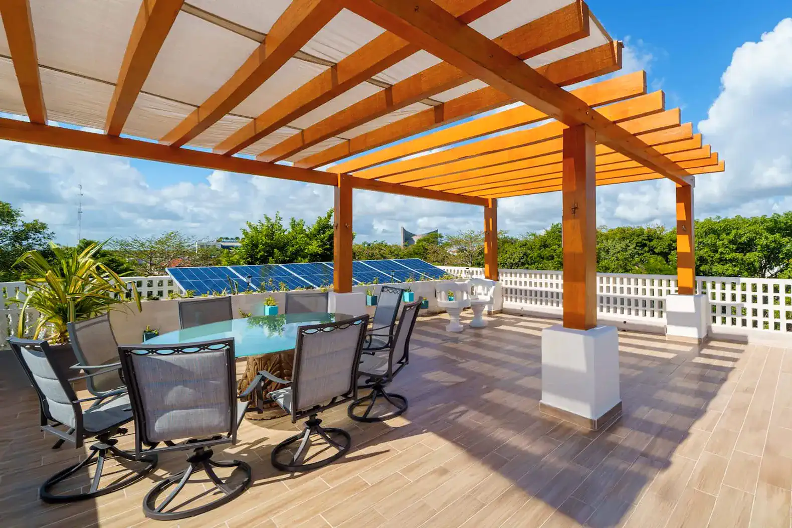 Spacious outdoor dining area with a pergola and views of solar panels