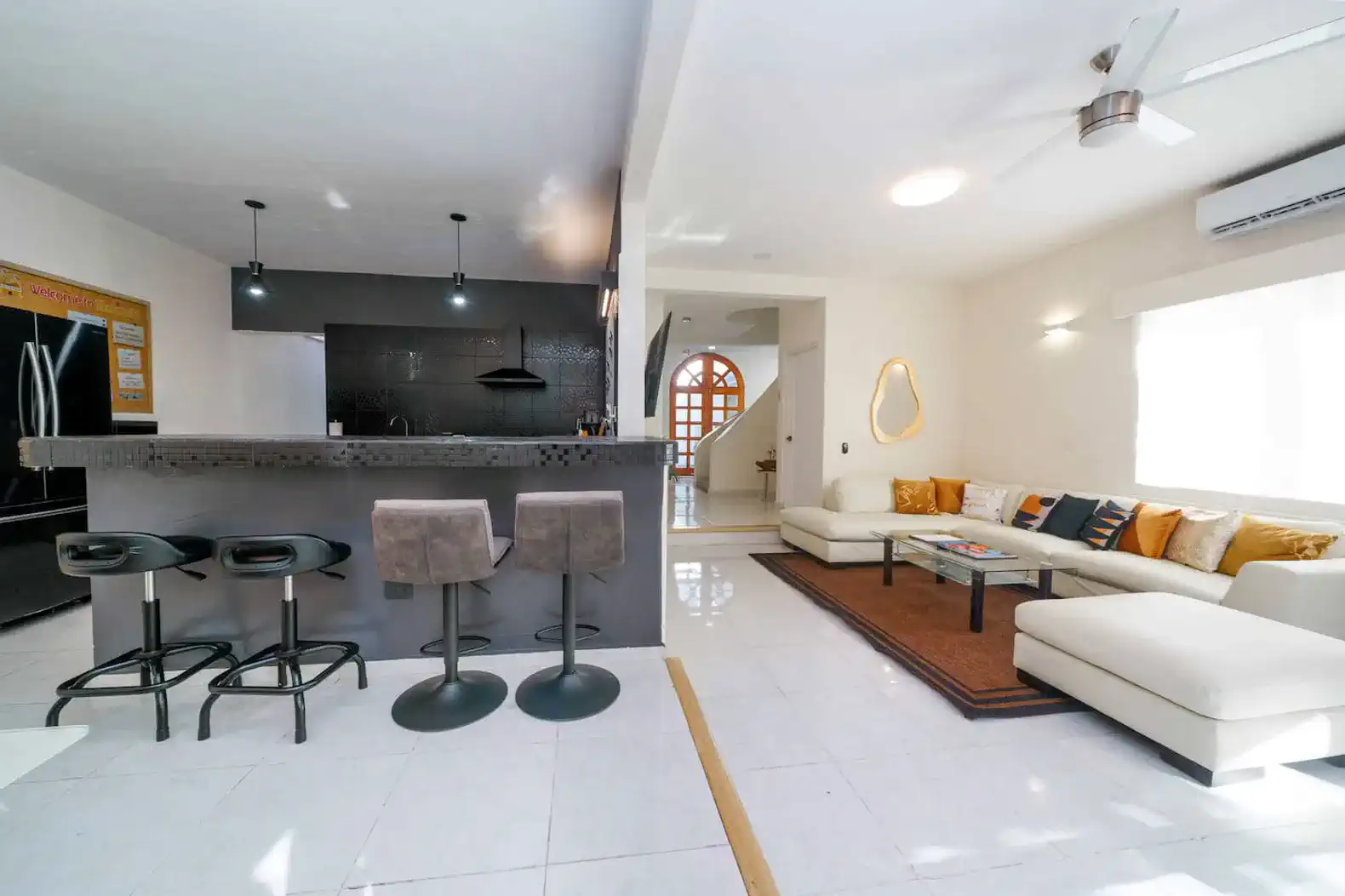 Spacious living area with modern furniture and open kitchen bar