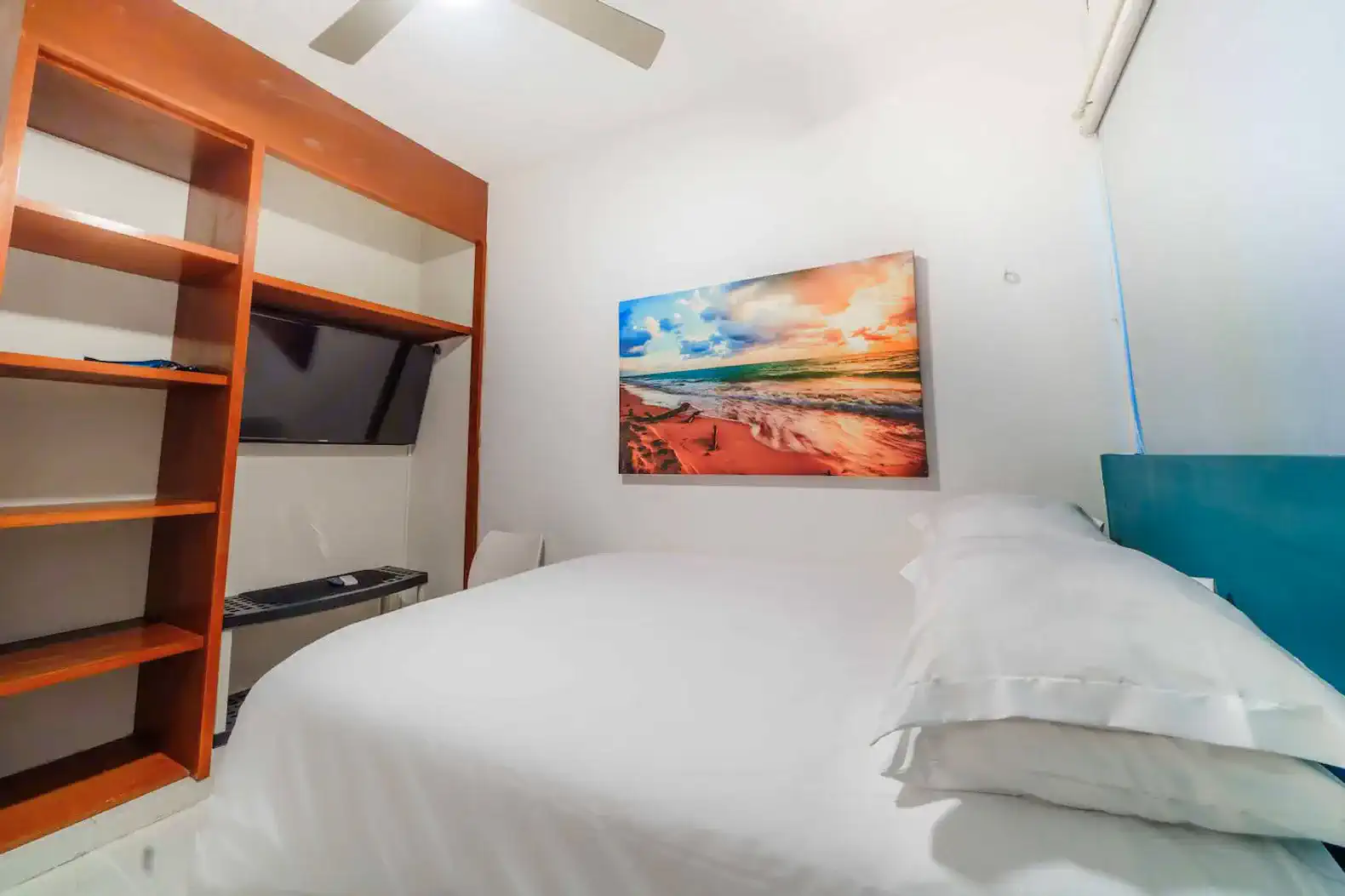 Cozy guest bedroom with a double bed and a colorful beach-themed painting