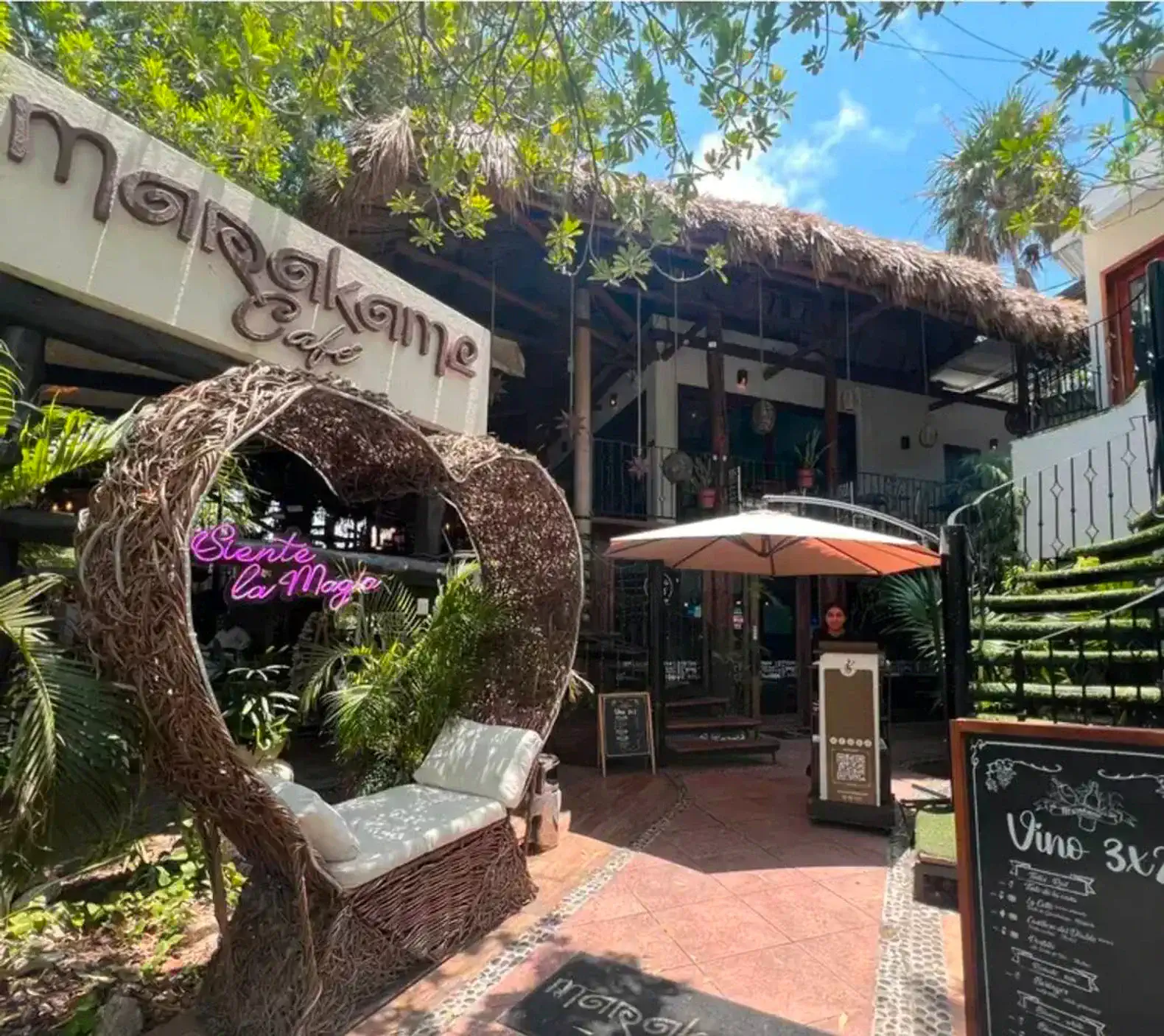 Charming entrance with a cozy seating area and tropical greenery