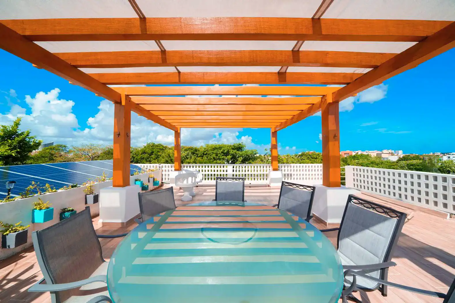 Spacious outdoor dining area with a wooden pergola and scenic views