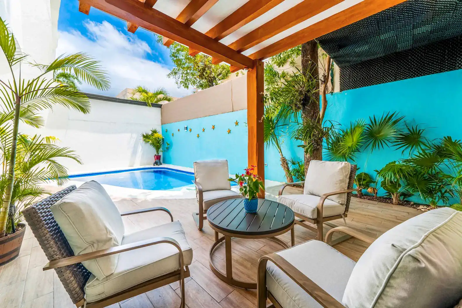 Cozy outdoor seating area by the private pool surrounded by tropical plants