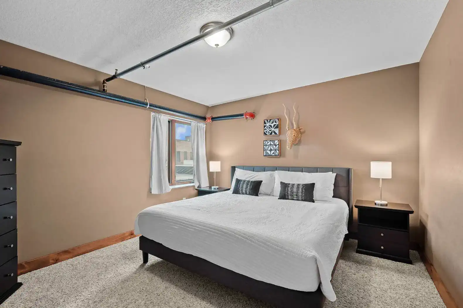 Another bedroom with a king sized bed, smart TV, closet, dresser, room darkening curtains and more!