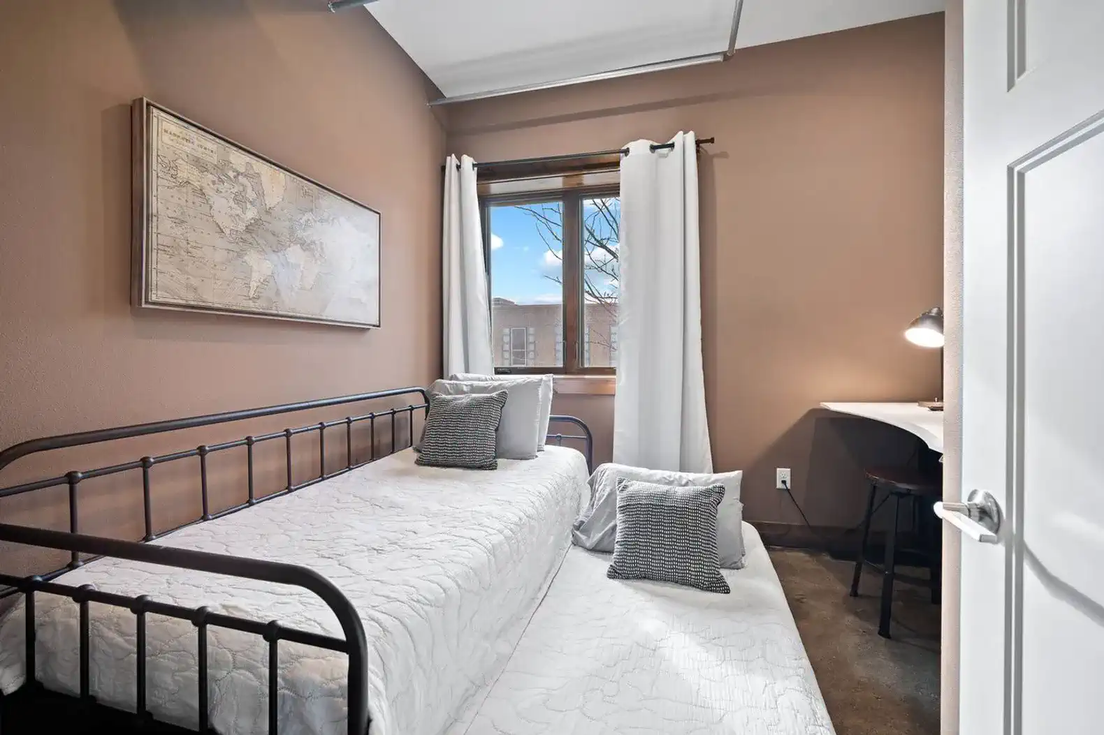 This cozy bedroom has a trundle bed as well as accompanying linens and blackout curtains.