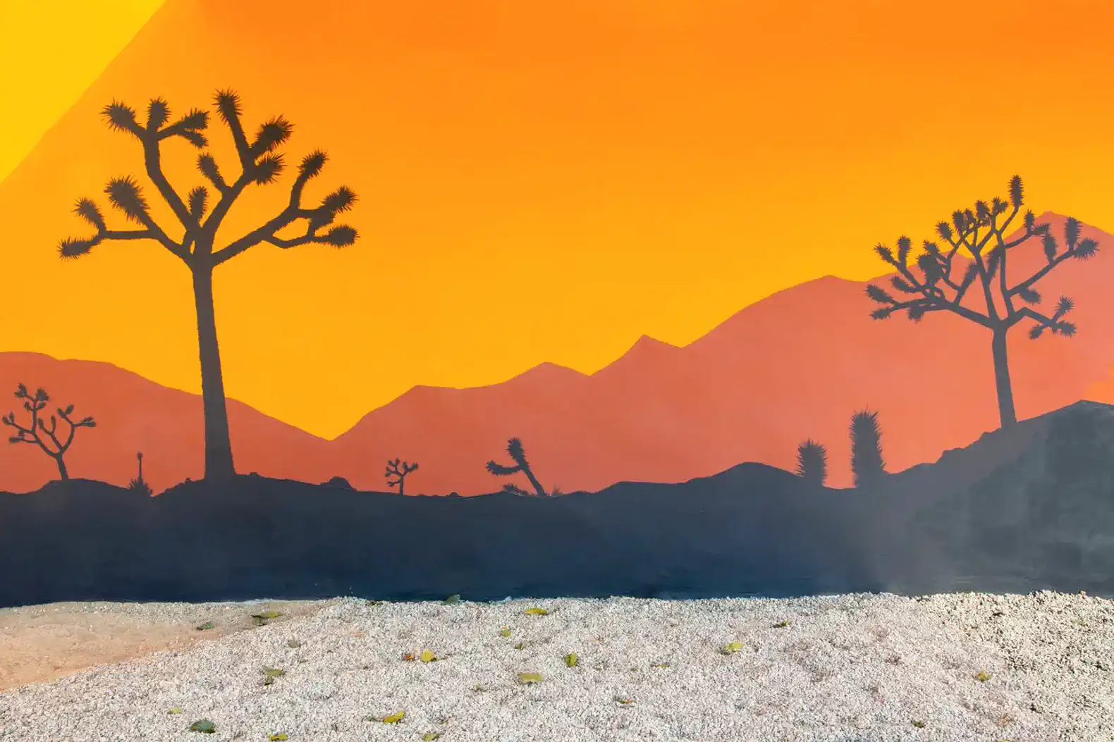 Colorful desert mural featuring silhouettes of Joshua trees and mountains