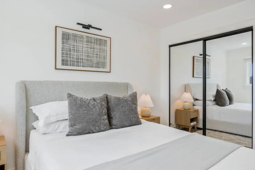 Dormitorio de invitados acogedor con una cama cómoda y armario con espejo