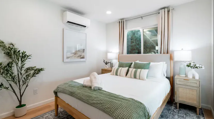 Gemütliches Hauptschlafzimmer mit großem Bett, weichen Bettwäsche und natürlichem Licht von einem Fenster