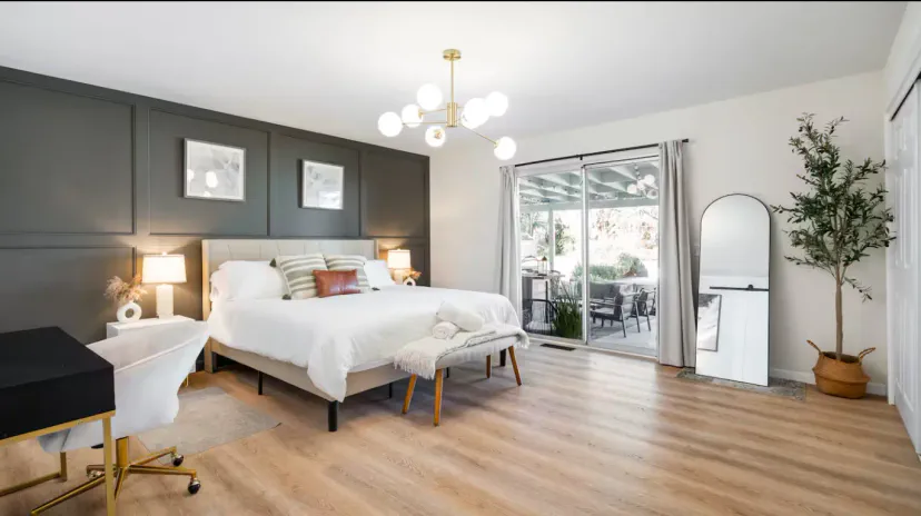 Geräumiges Hauptschlafzimmer mit einem großen Bett, modernem Dekor und Schiebetüren zu einer Außenterrasse
