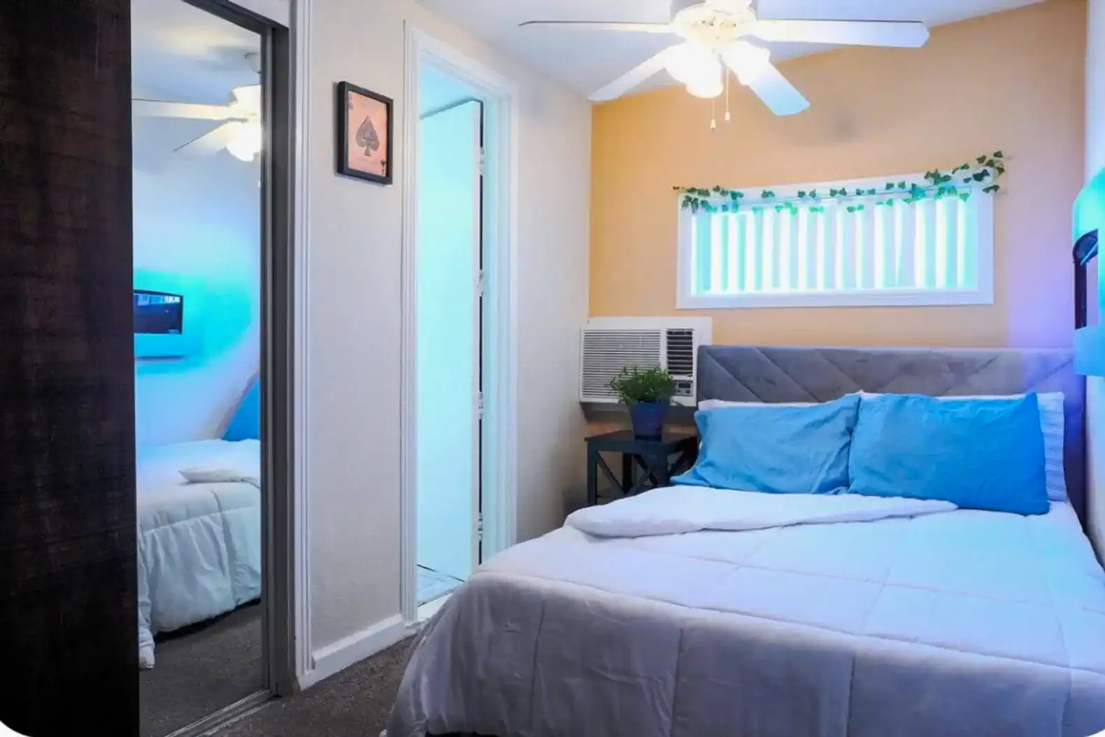 Cozy guest bedroom with a bed, ceiling fan, and mirrored closet