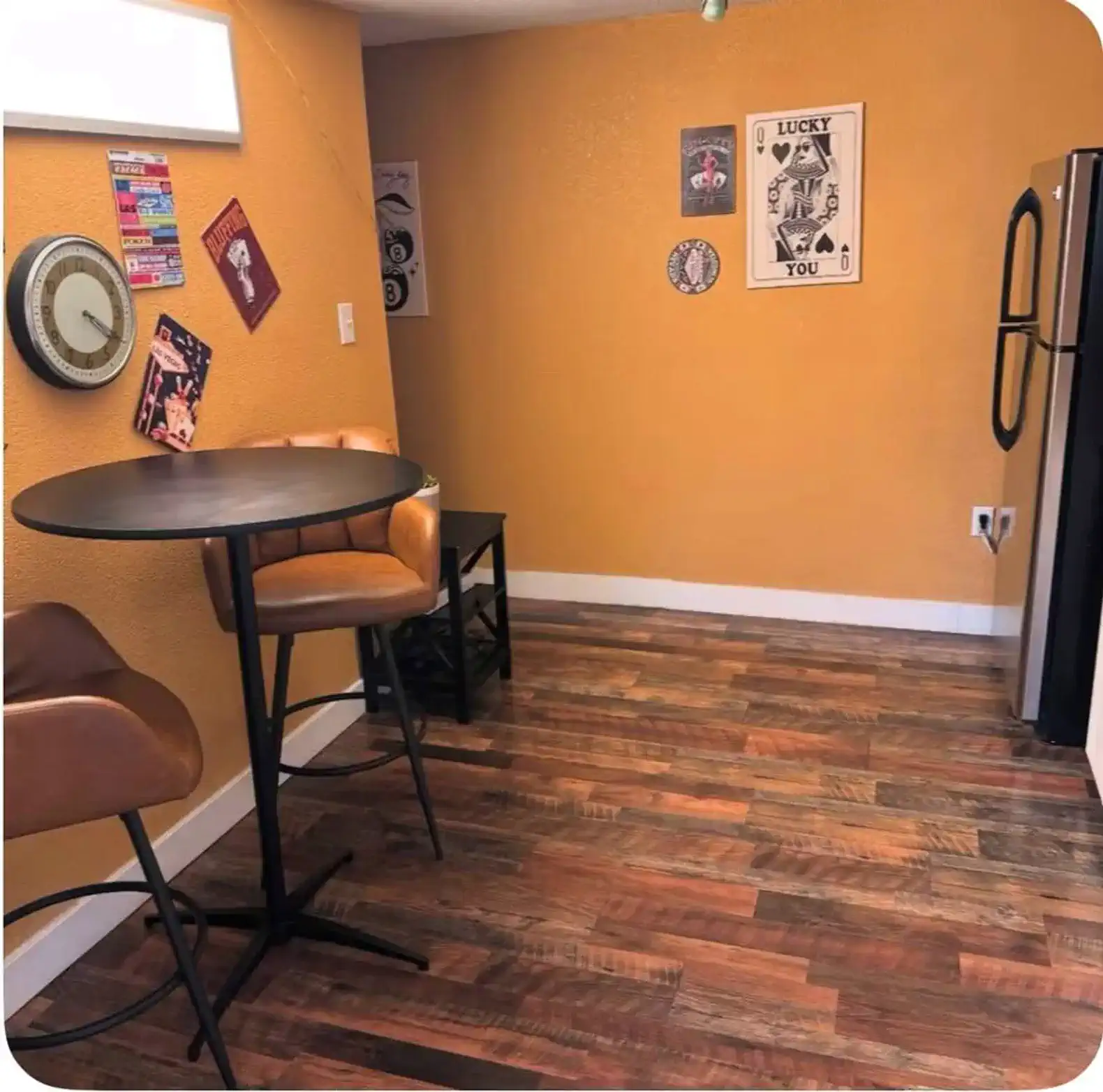 Cozy dining area with a small round table and two chairs against a warm orange wall