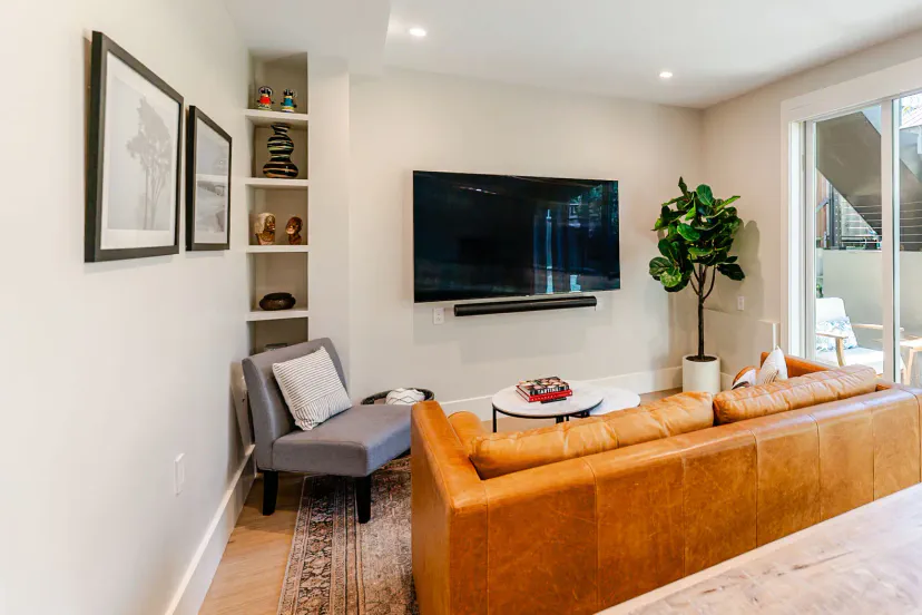 Gemütliches Wohnzimmer mit 75" NeoQLED 4k Smart TV, plüschigem Ledersofa mit modernem Queenschlafsofa