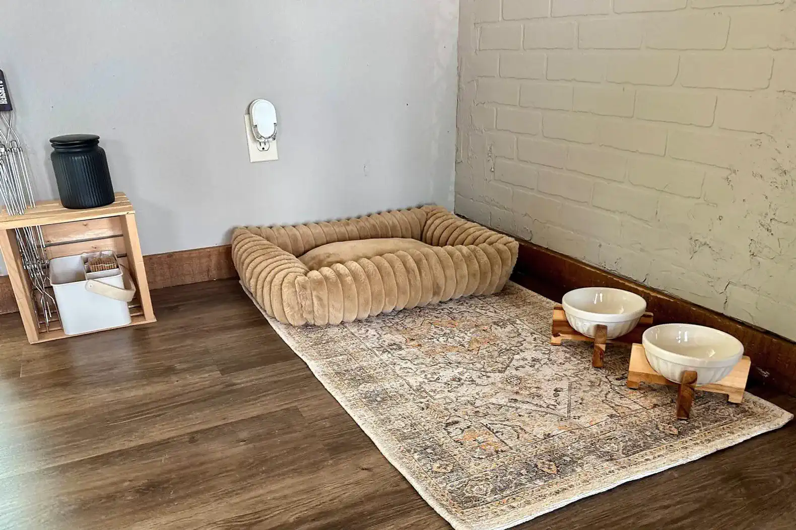 Cozy pet area with a soft bed and food bowls on a decorative rug