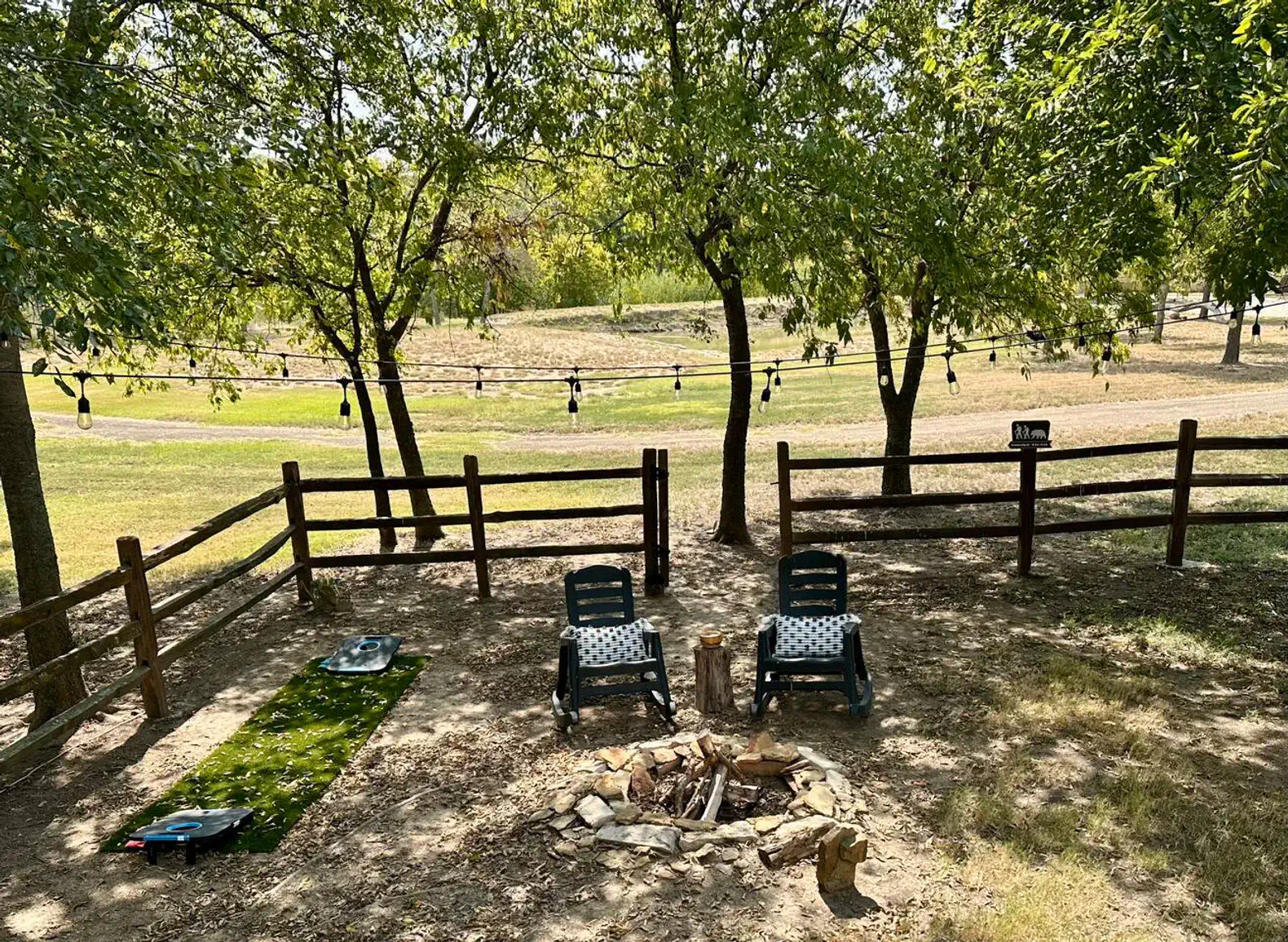 Cozy outdoor seating area with chairs and a fire pit surrounded by trees