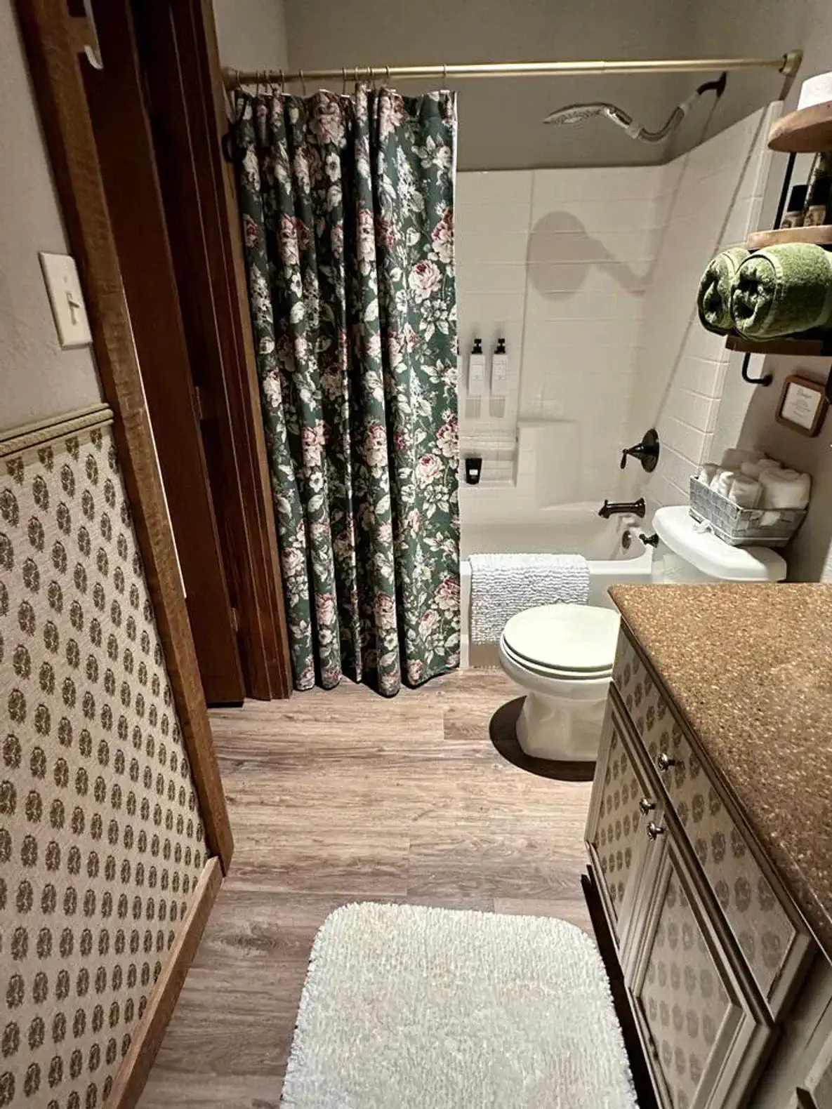 Cozy bathroom featuring floral shower curtain, tub, and modern vanity