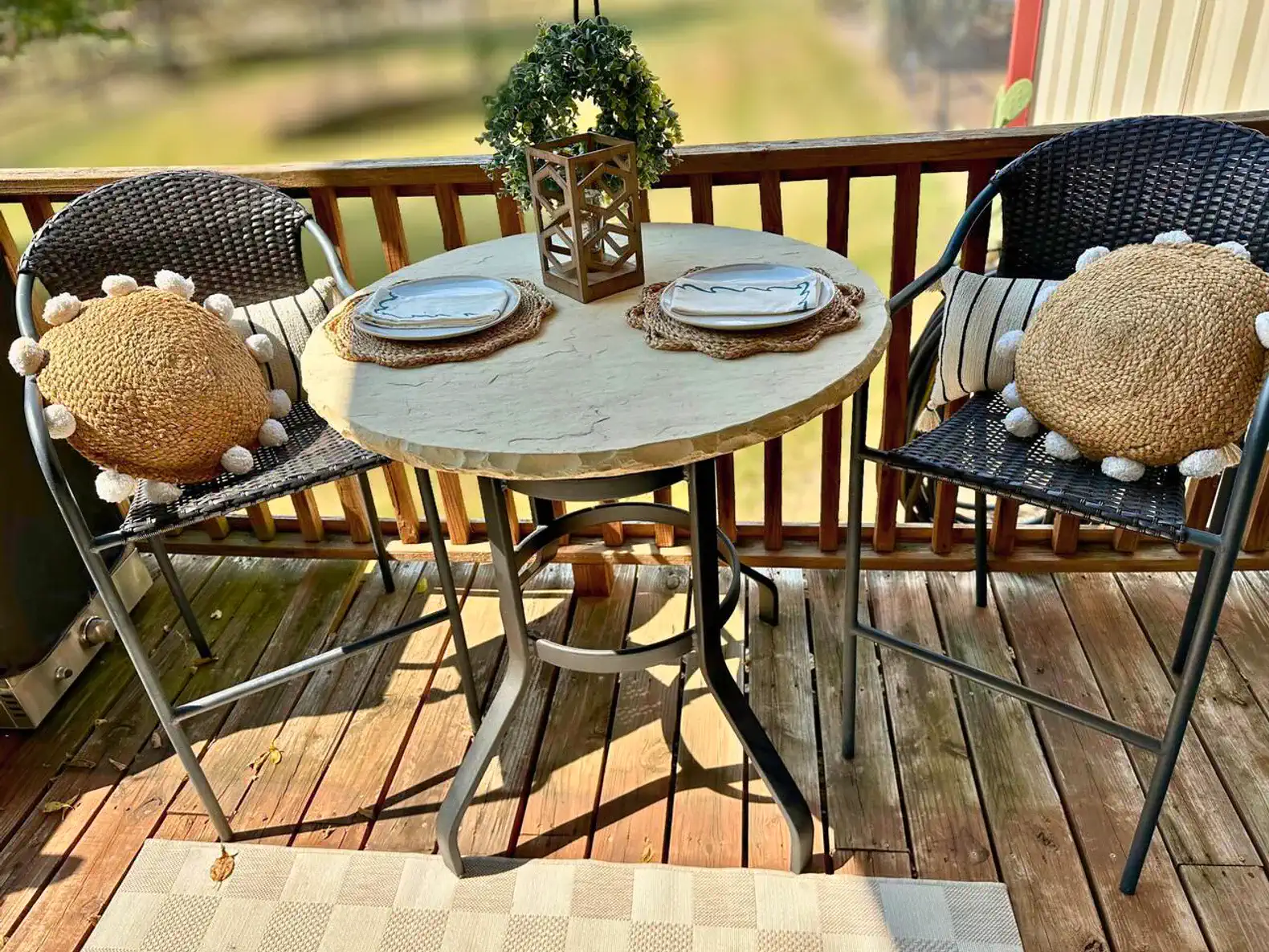 Cozy outdoor dining setup with a round table and two chairs on a wooden deck