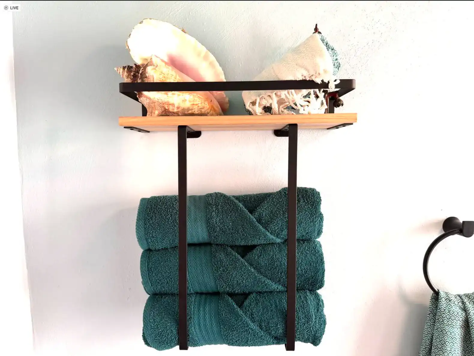 Prateleira com conchas e toalhas de banho em tons de azul