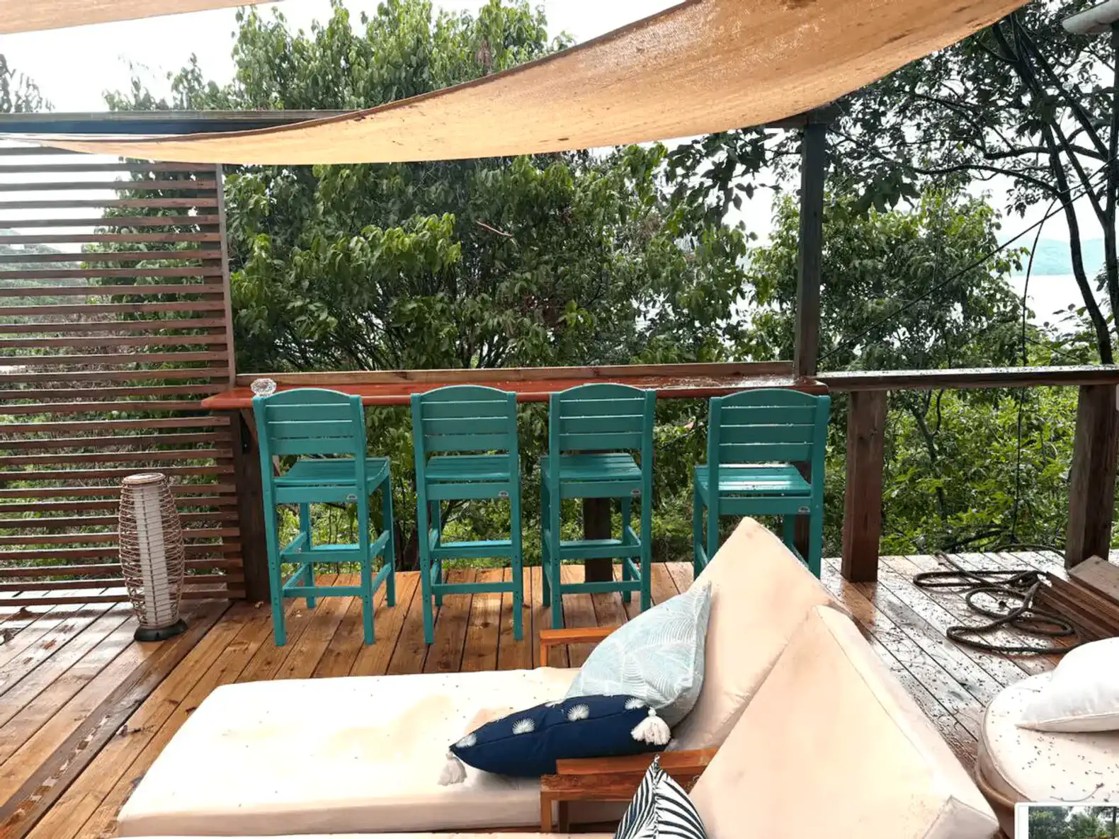 Outdoor seating area with turquoise chairs and a view of lush greenery