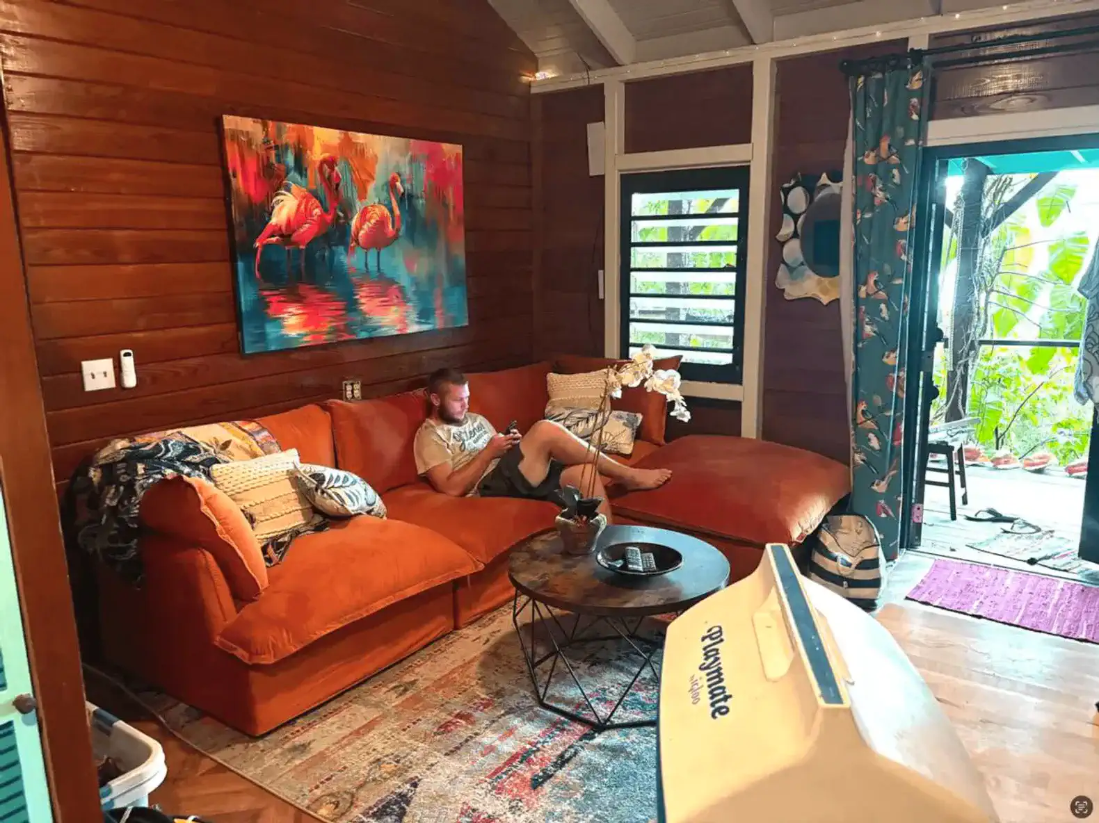 Cozy living room with orange sectional sofa and vibrant artwork