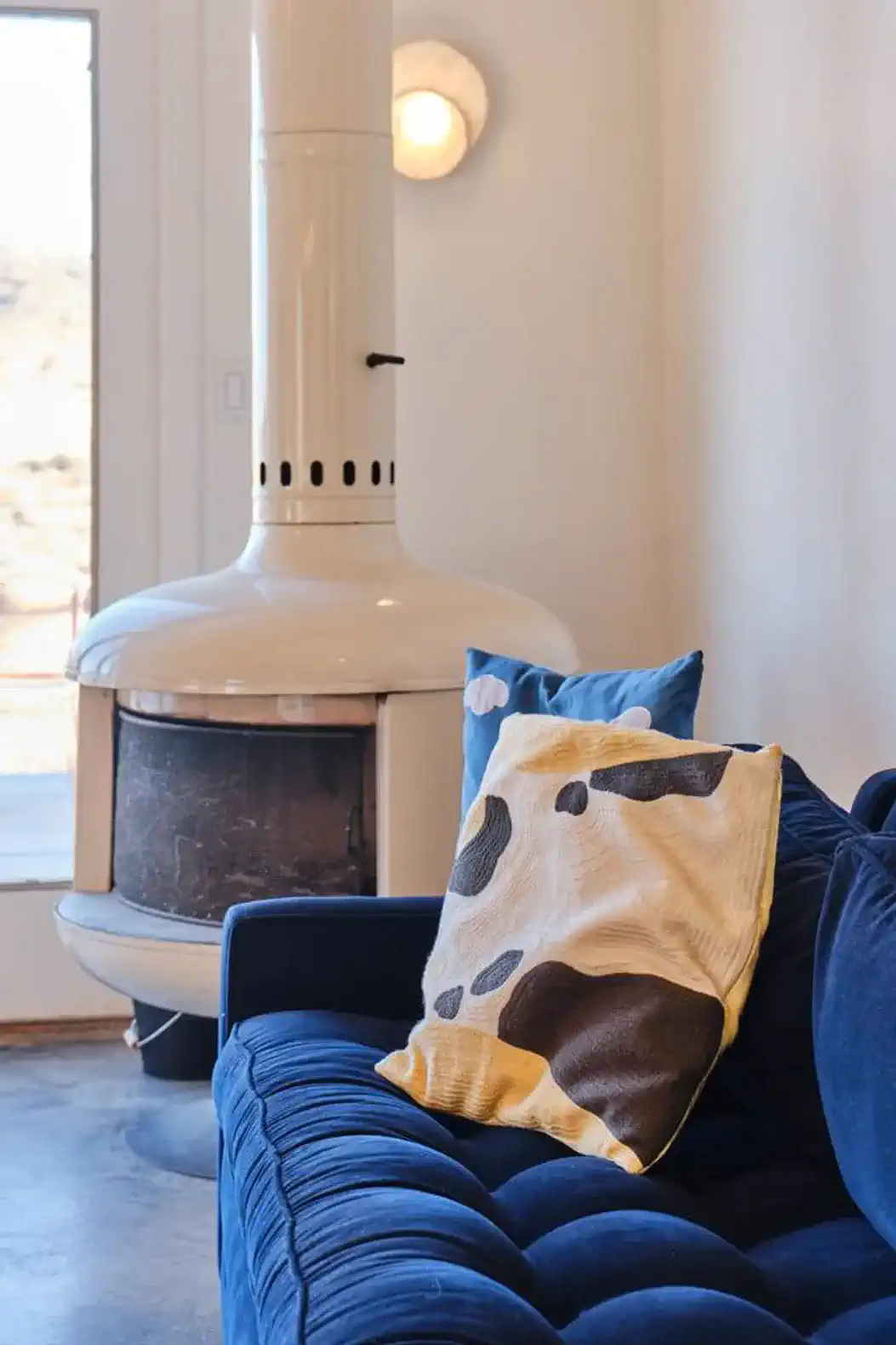Cozy living room with a blue couch and a unique white fireplace