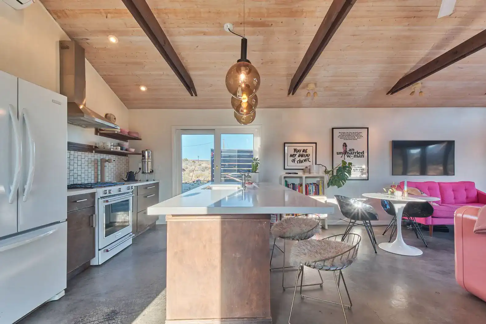 Modern kitchen with island, stainless steel appliances, and open layout to living area