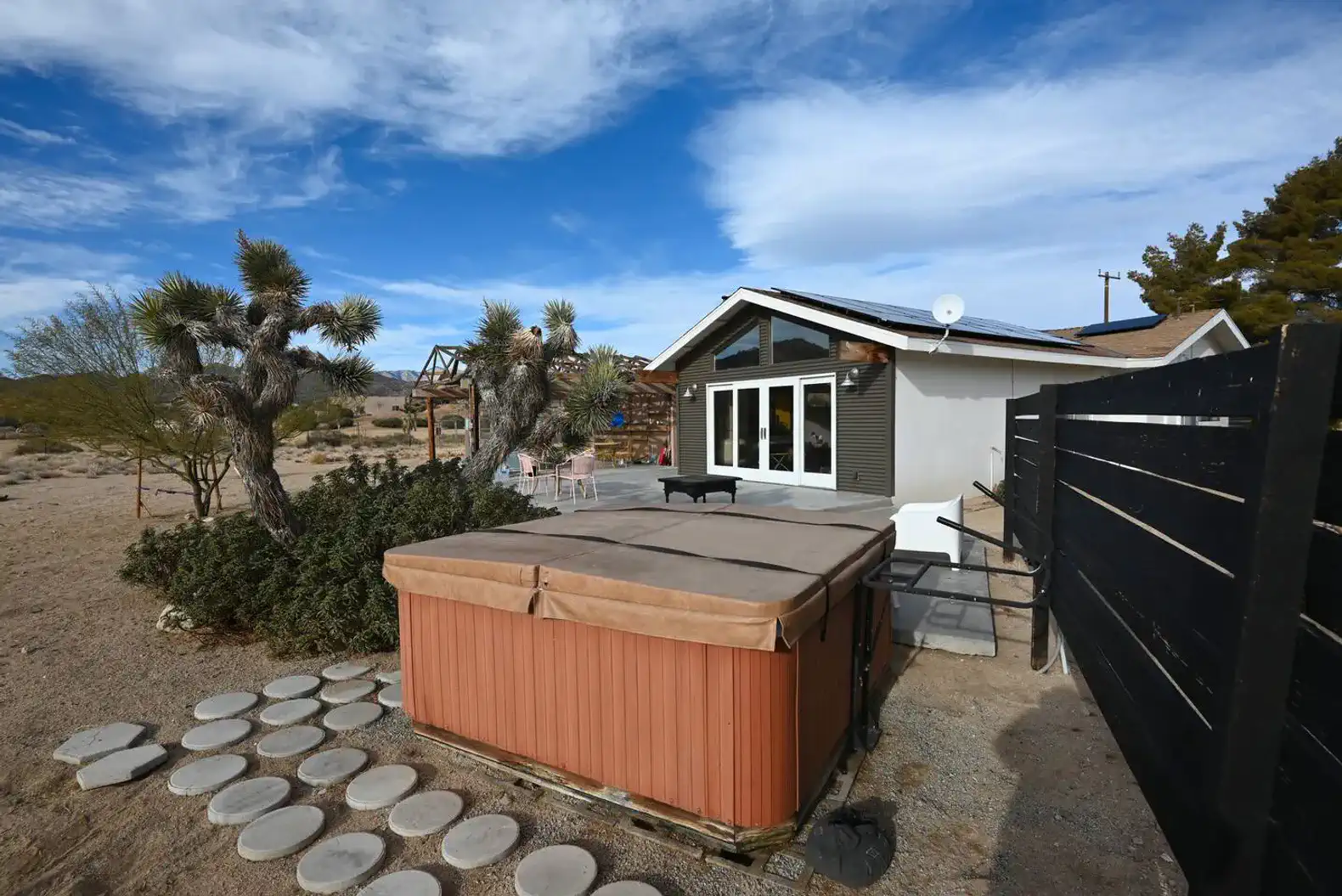 Hot tub surrounded by desert landscape and Joshua trees