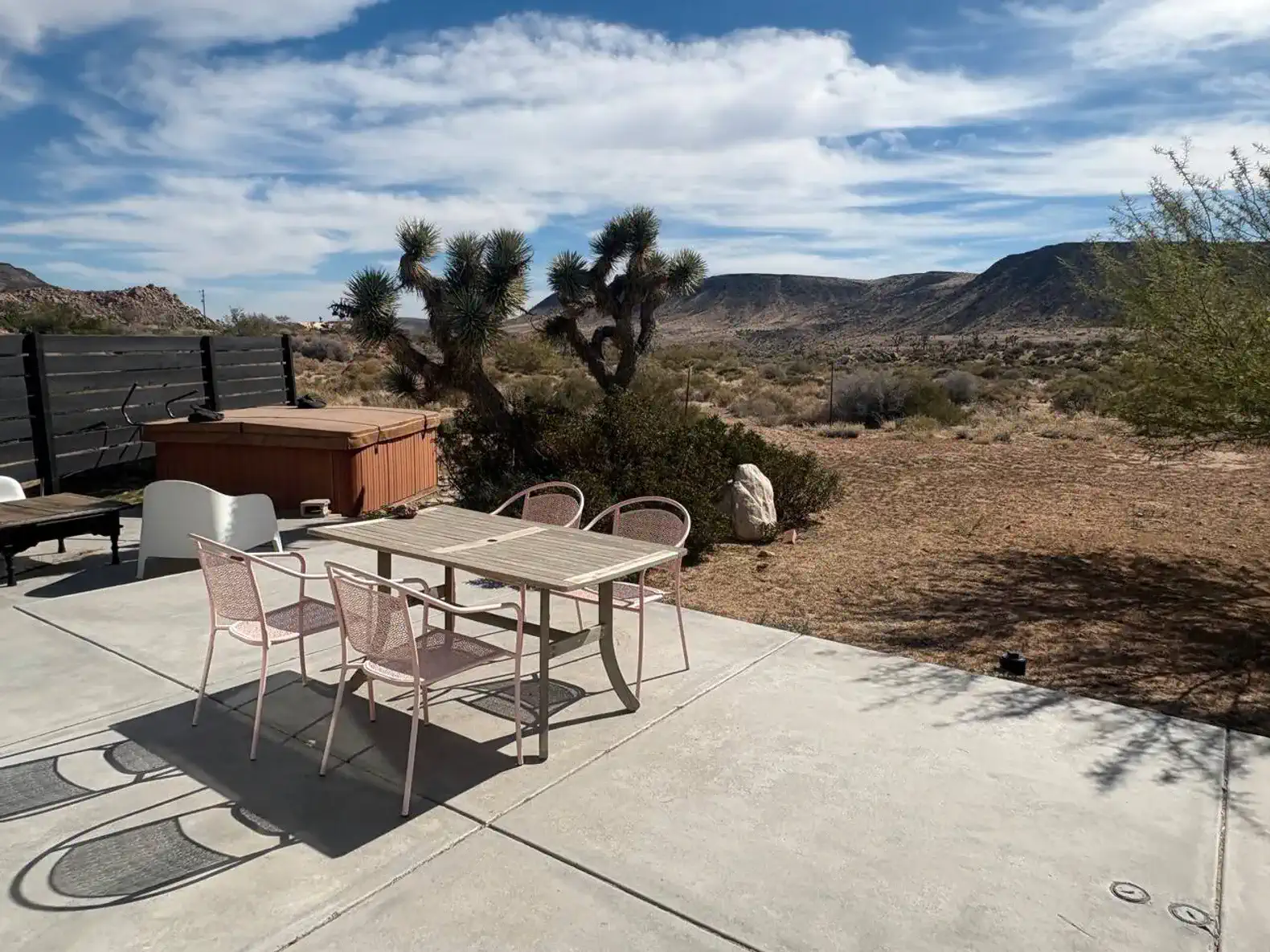 Outdoor dining area with a table and chairs overlooking desert landscape