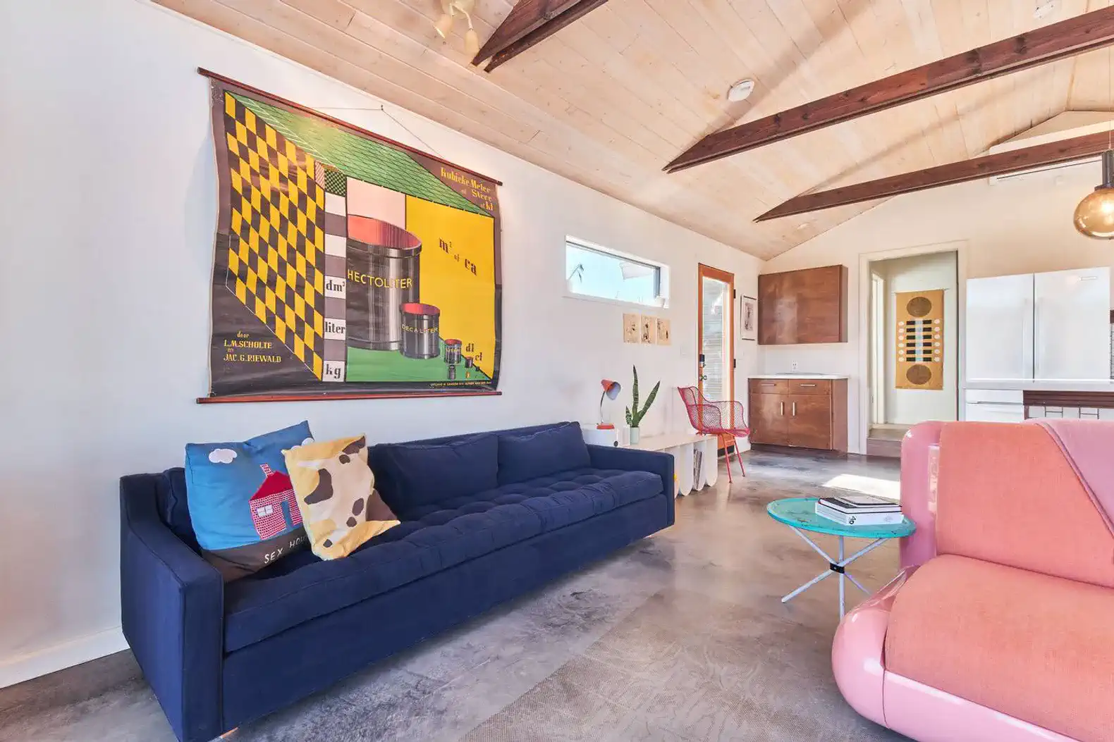 Stylish living room with a blue sofa, colorful artwork, and modern decor