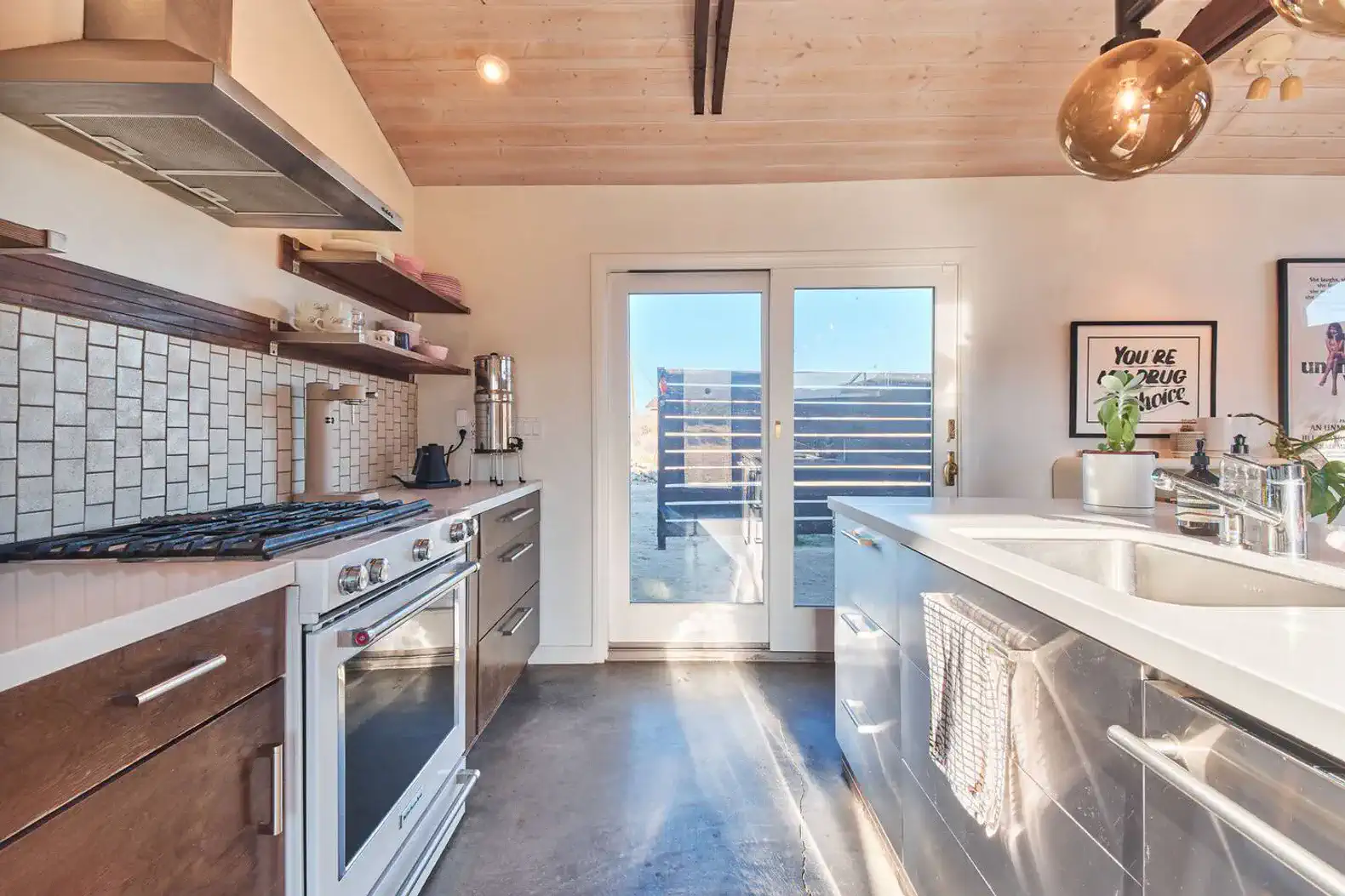 Modern kitchen with stainless steel appliances and sliding glass doors to outdoor area