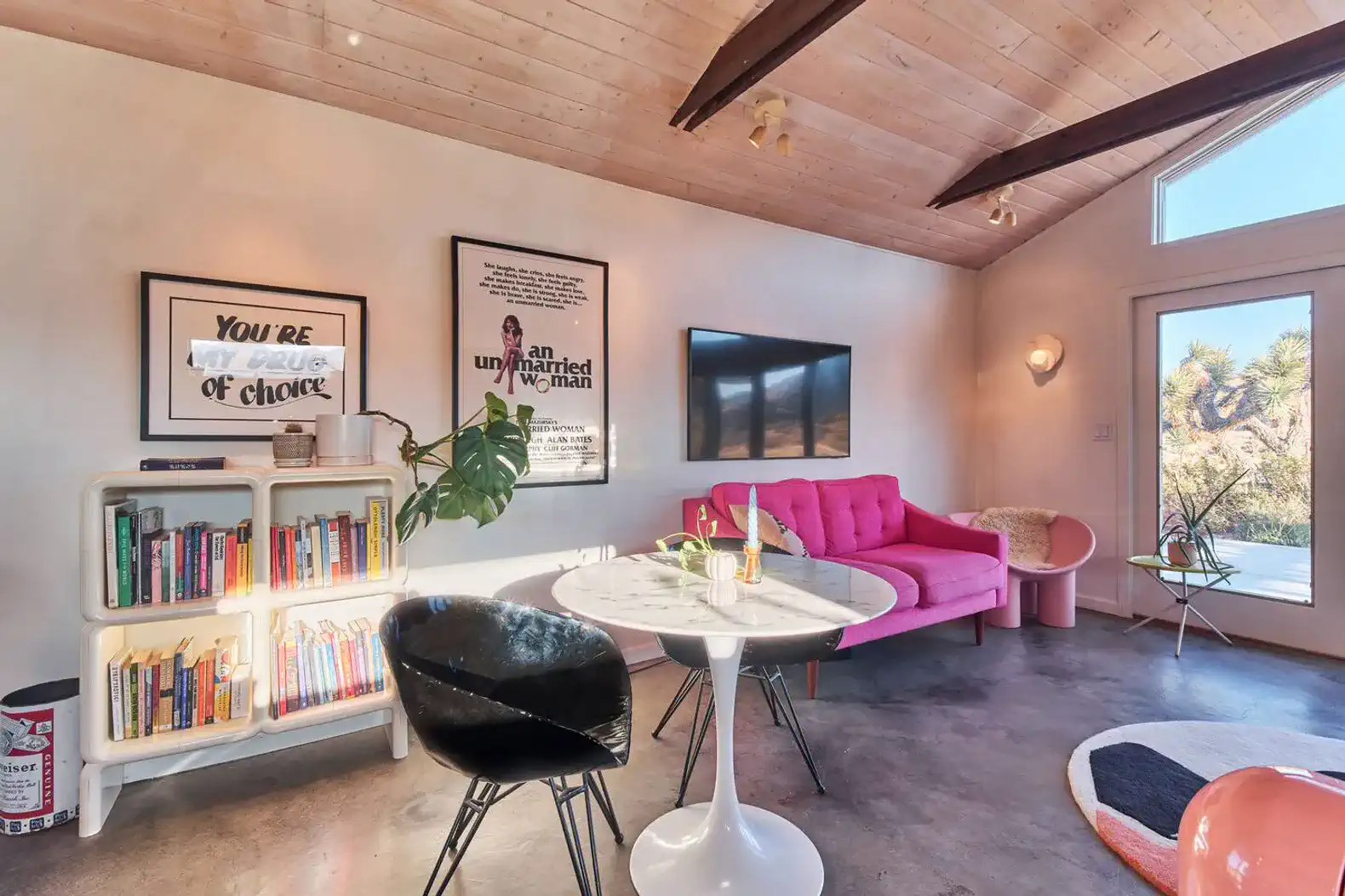 Stylish living room with pink sofa, modern decor, and large windows for natural light