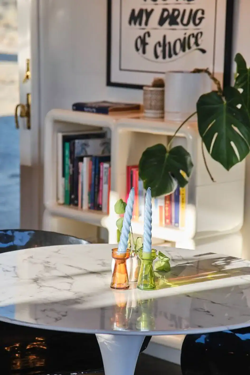 Stylish dining table with colorful candle holders and a plant centerpiece