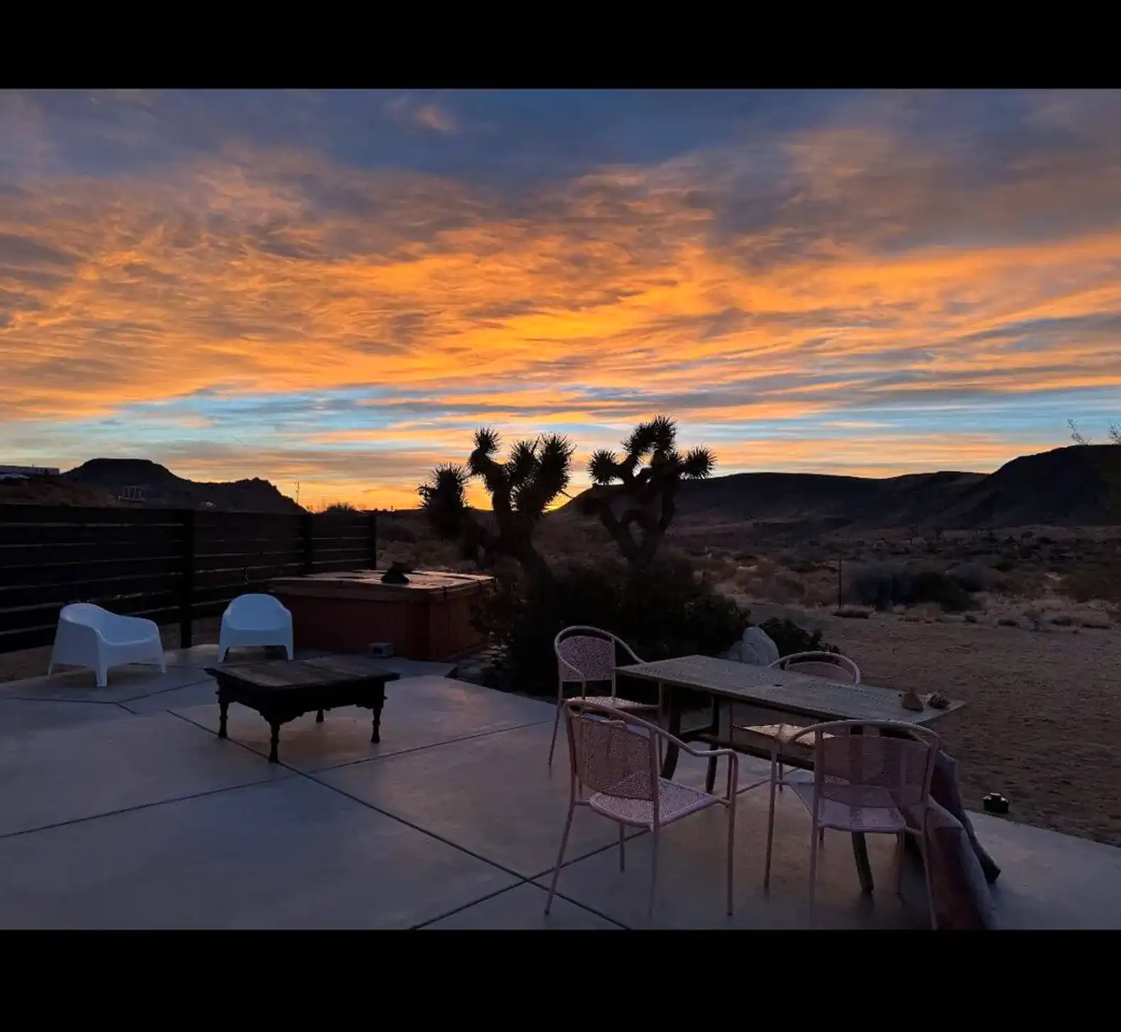 Outdoor patio with a table and chairs overlooking a stunning desert sunset