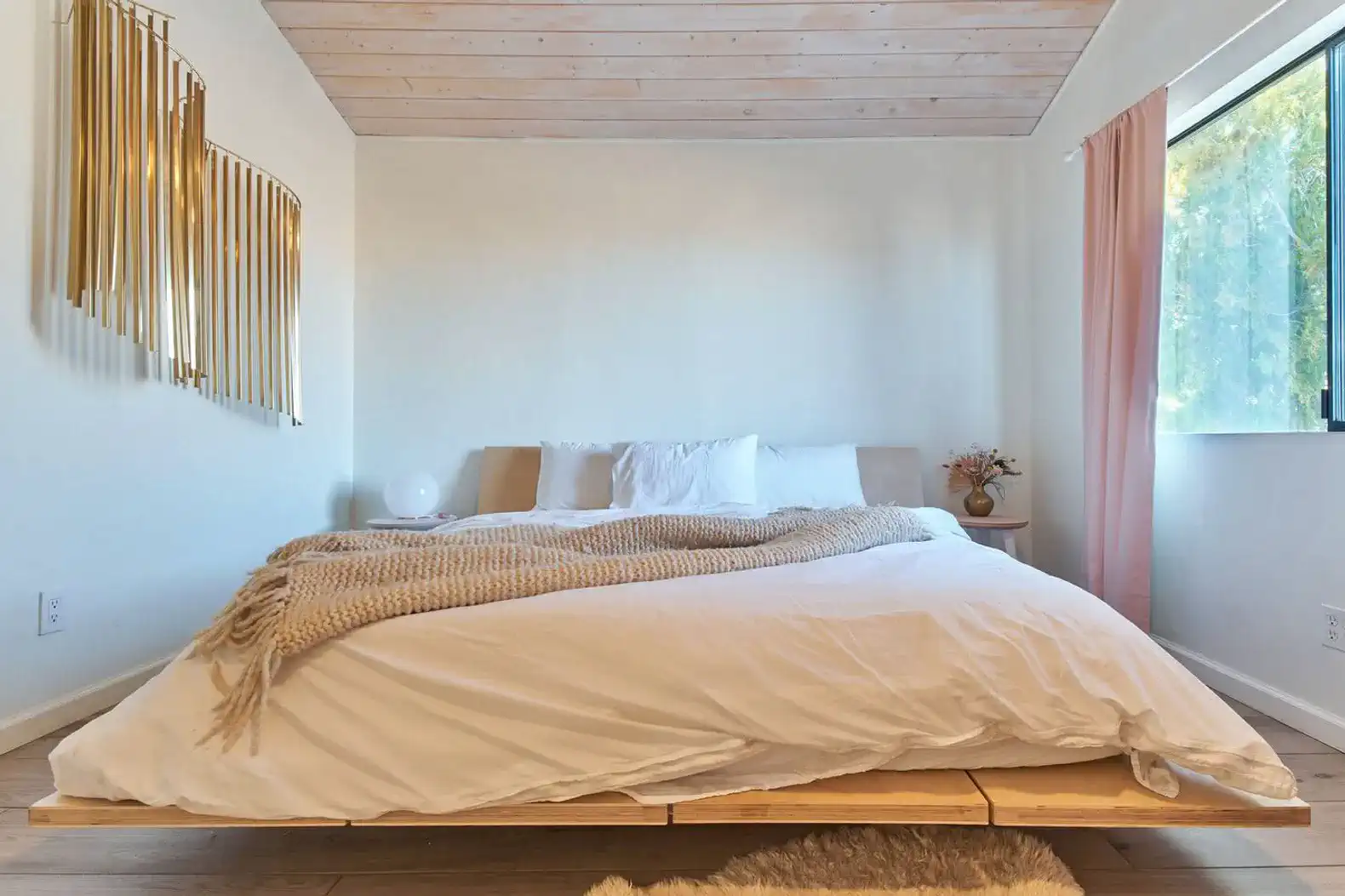 Cozy master bedroom with a wooden bed, soft bedding, and natural light