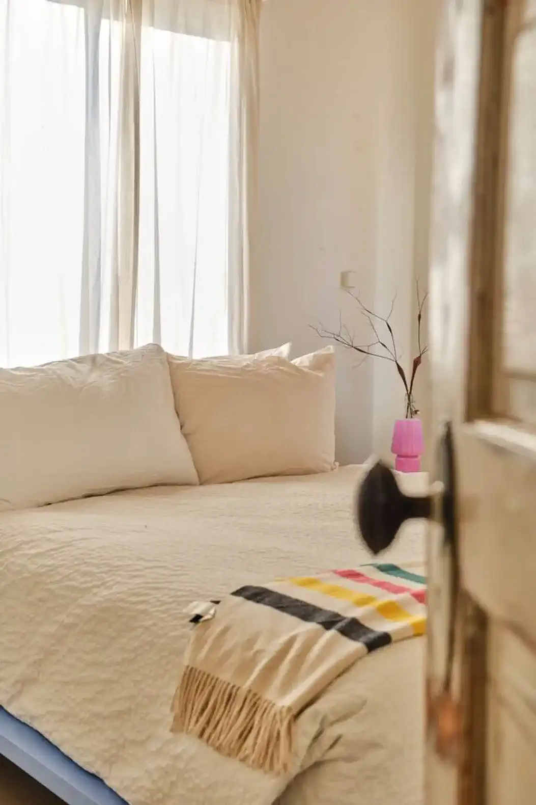 Cozy bedroom with a large bed, natural light, and minimalist decor