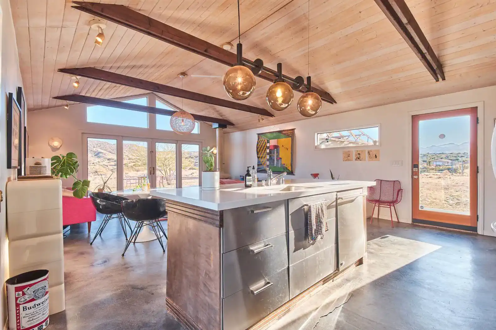 Modern kitchen with a large island, pendant lighting, and panoramic windows showcasing desert views