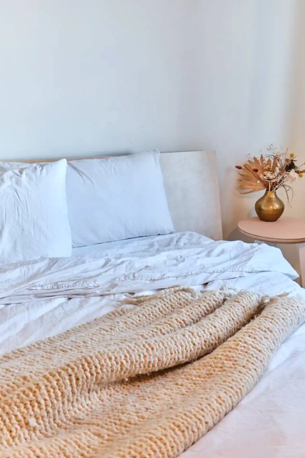 Cozy master bedroom with a neatly made bed and decorative vase on a nightstand