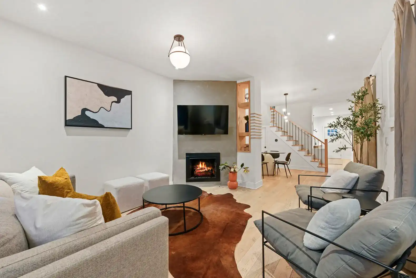 Cozy living room with modern decor, fireplace, and comfortable seating