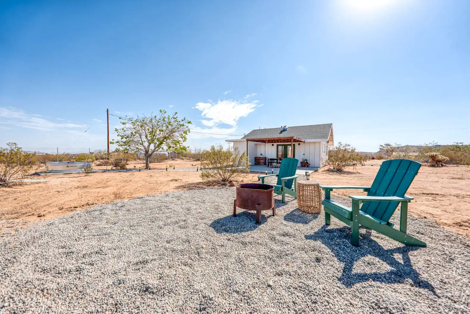 Cozy outdoor seating area with green chairs and fire pit in a desert landscape