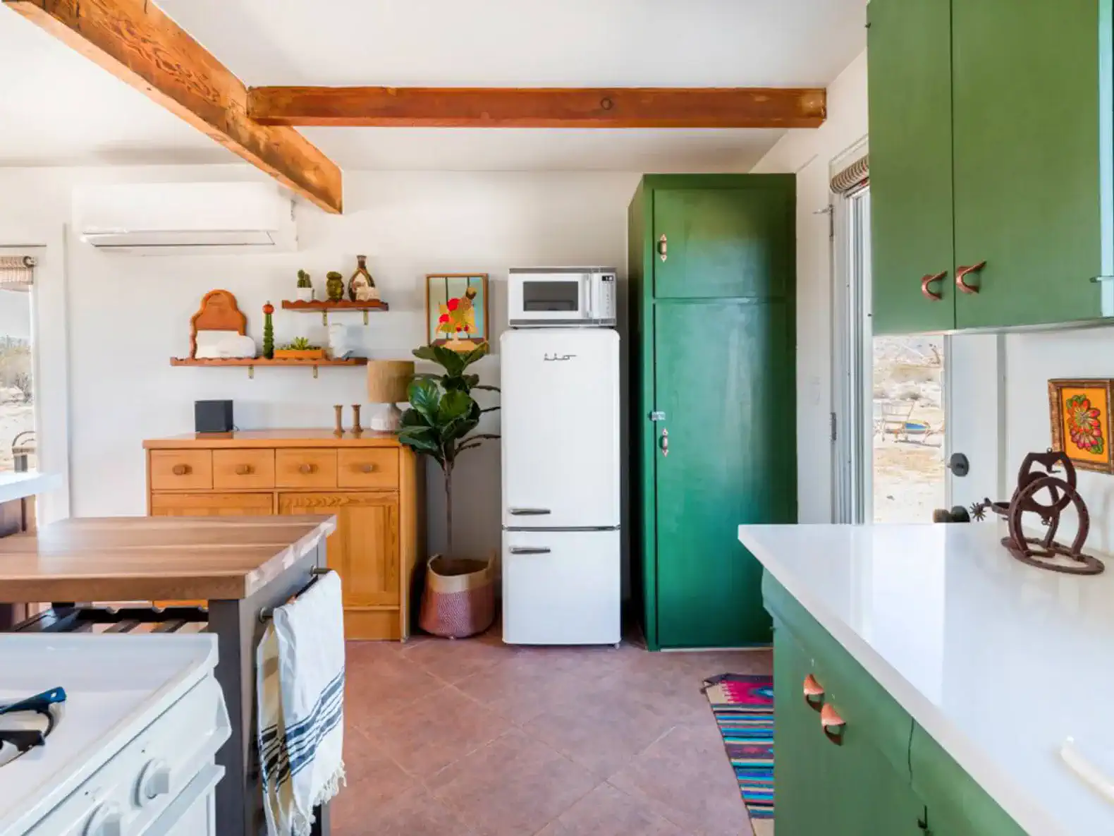 Bright kitchen with green cabinets, white countertops, and modern appliances
