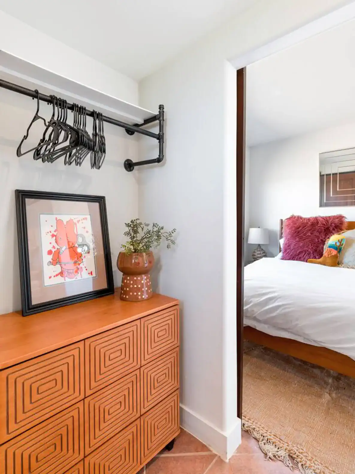 Cozy entryway with a decorative chest, artwork, and a glimpse of the guest bedroom