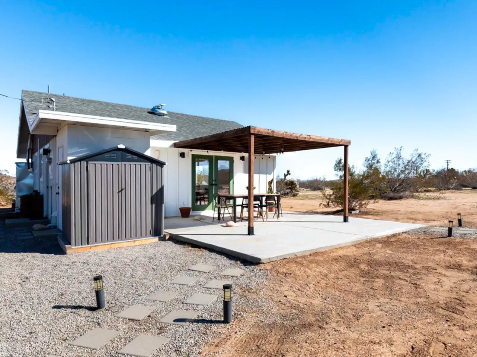 Outdoor patio area with a shaded seating space and desert landscape