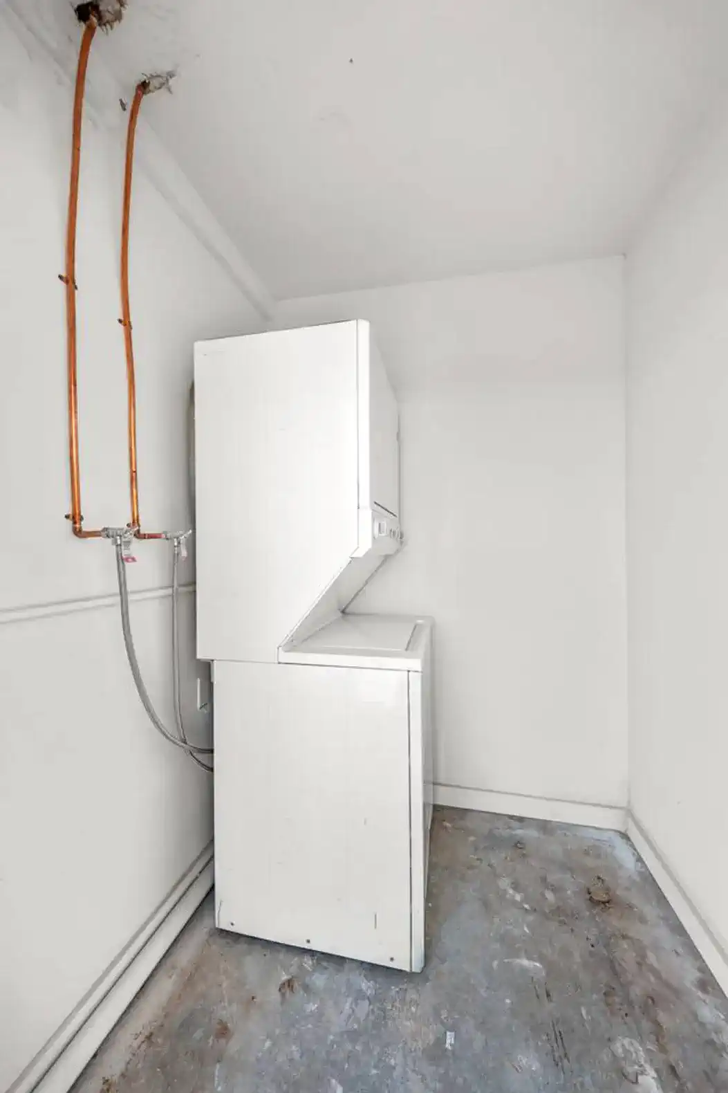 Laundry area with stacked washer and dryer in a minimalist space
