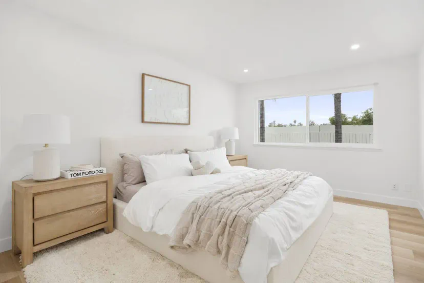 Bright and airy master bedroom with large window and neutral decor