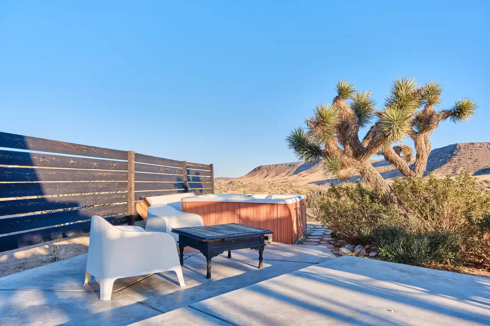 Outdoor seating area with a hot tub and desert landscape