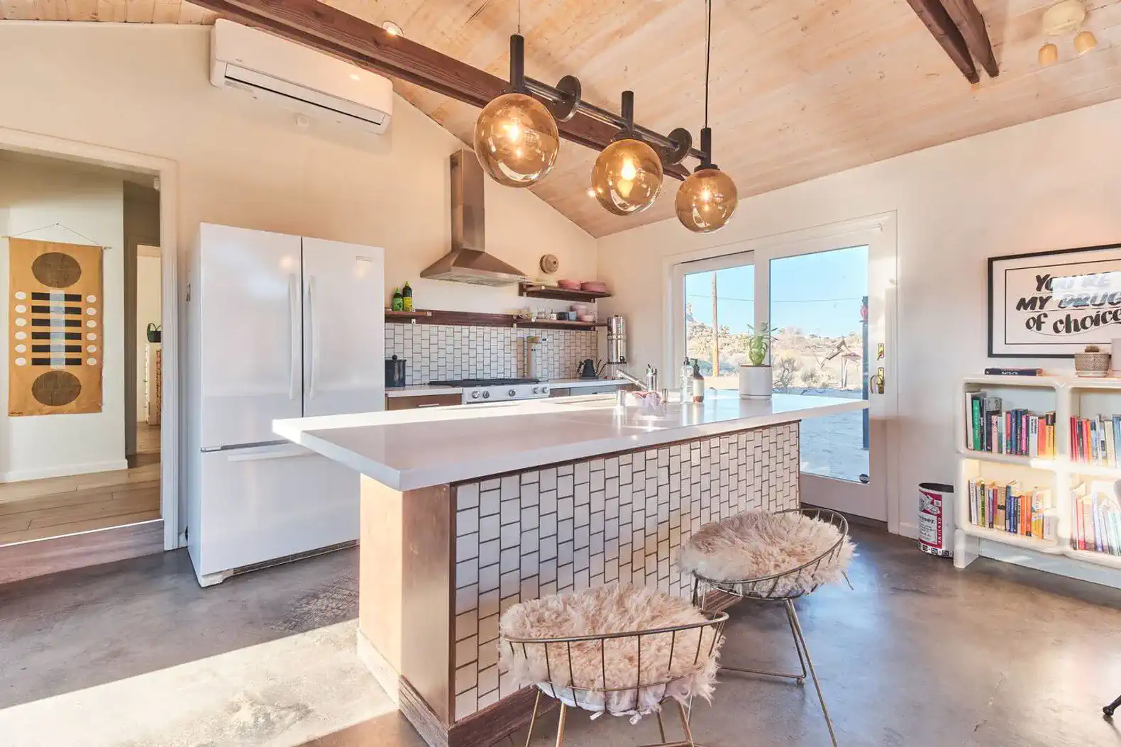 Modern kitchen with white cabinets, large island, and stylish pendant lighting