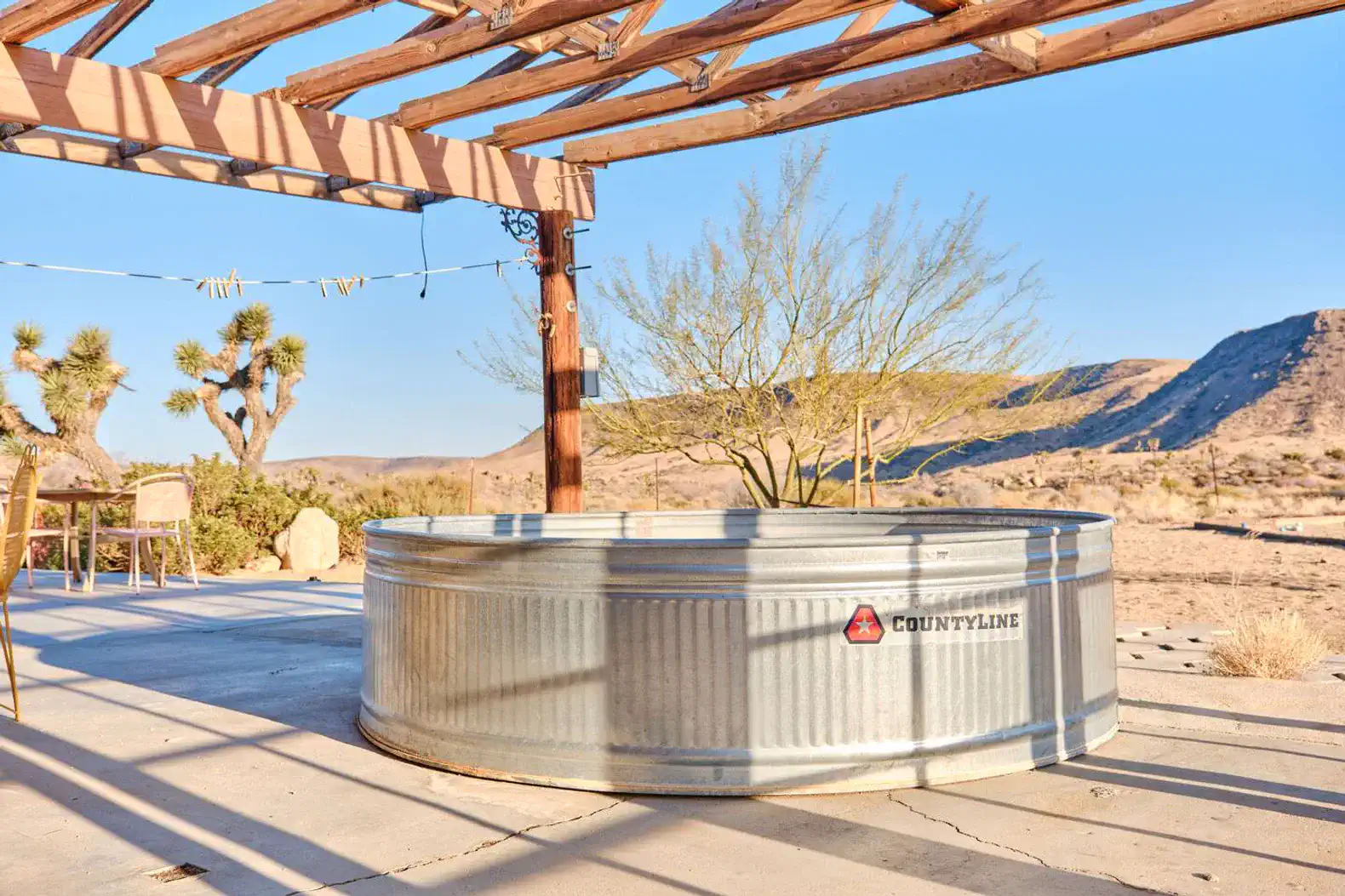Rustic outdoor area with a metal tub and desert landscape