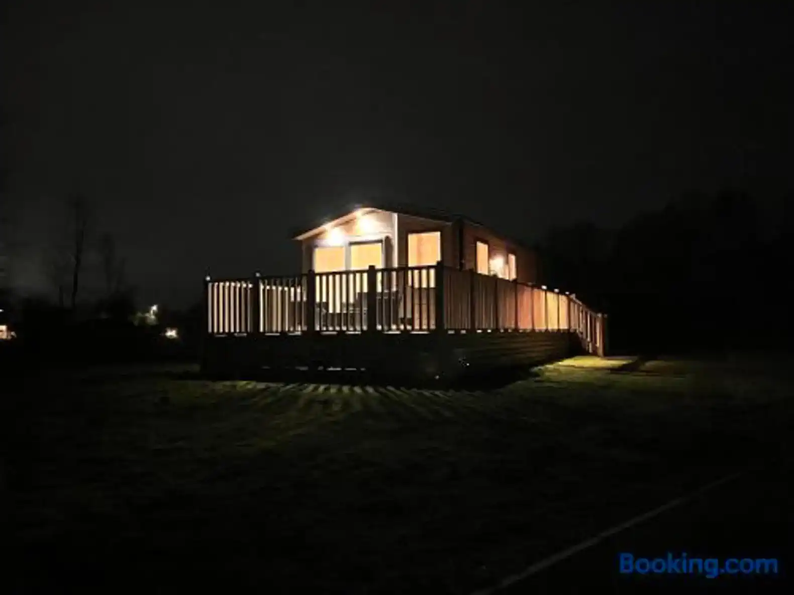 Cozy cabin illuminated at night with a spacious deck