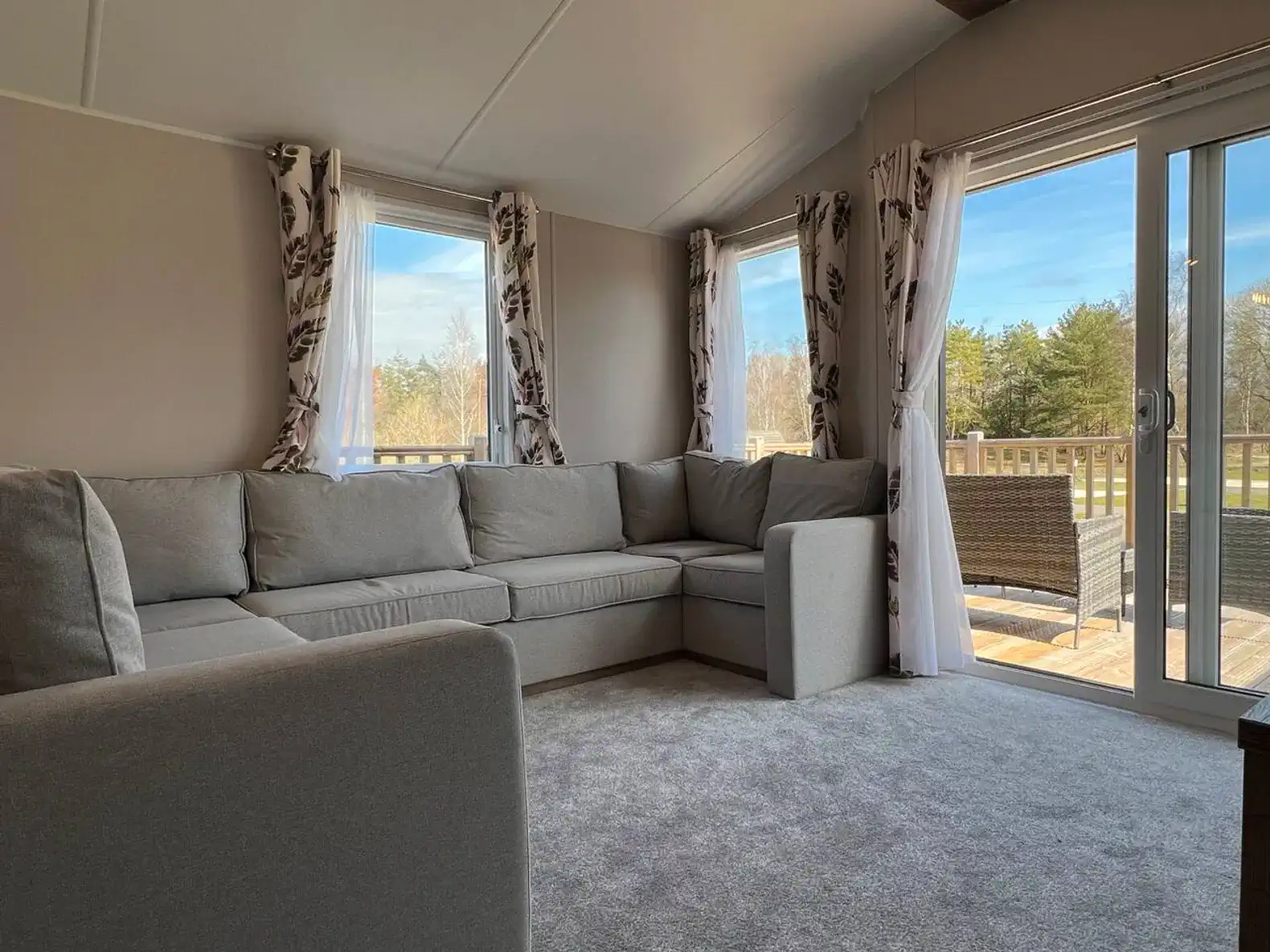 Cozy living area with large sectional sofa and windows overlooking the outdoor deck