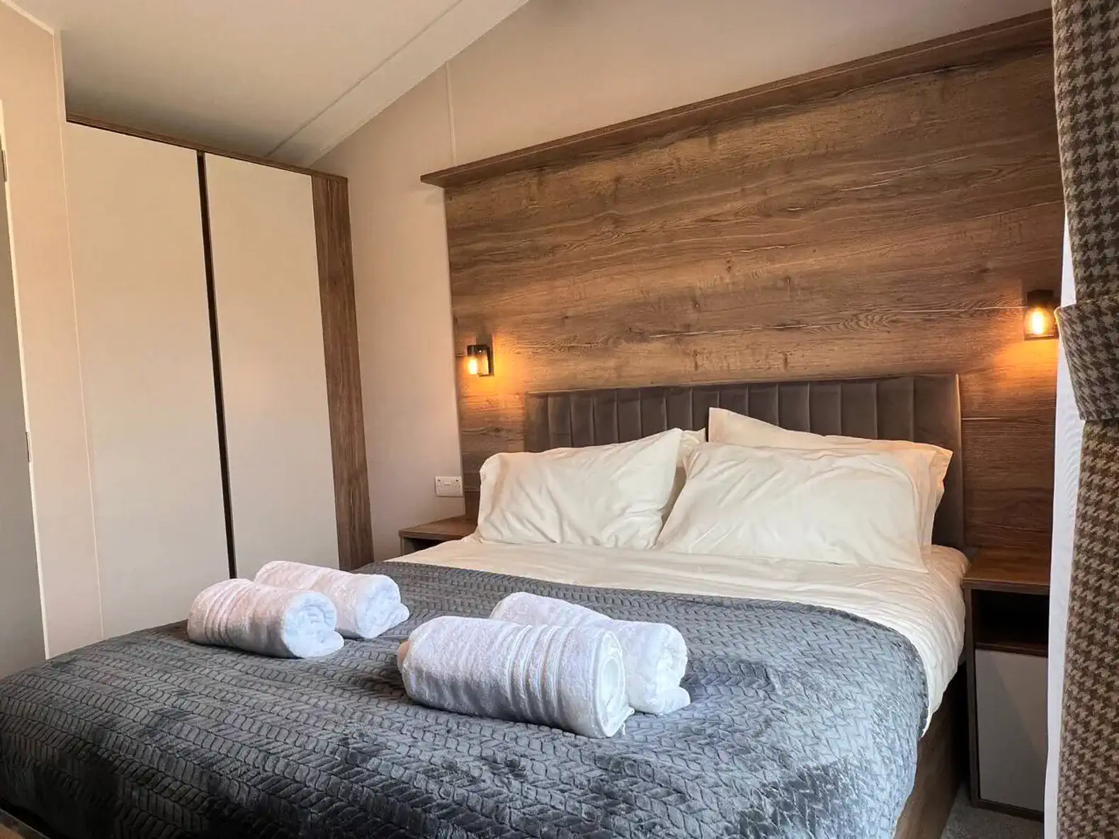 Cozy master bedroom with a large bed, soft linens, and stylish wooden accents