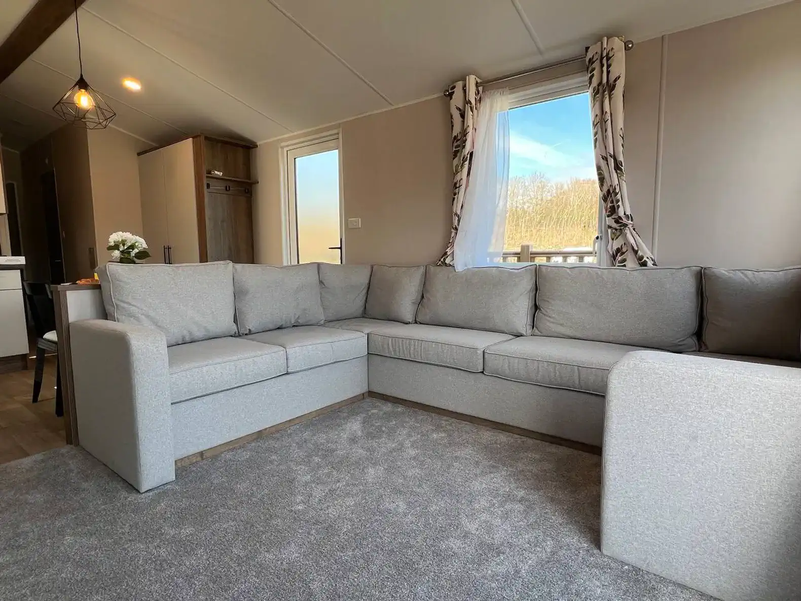 Cozy gray sectional sofa in a bright living area with large windows